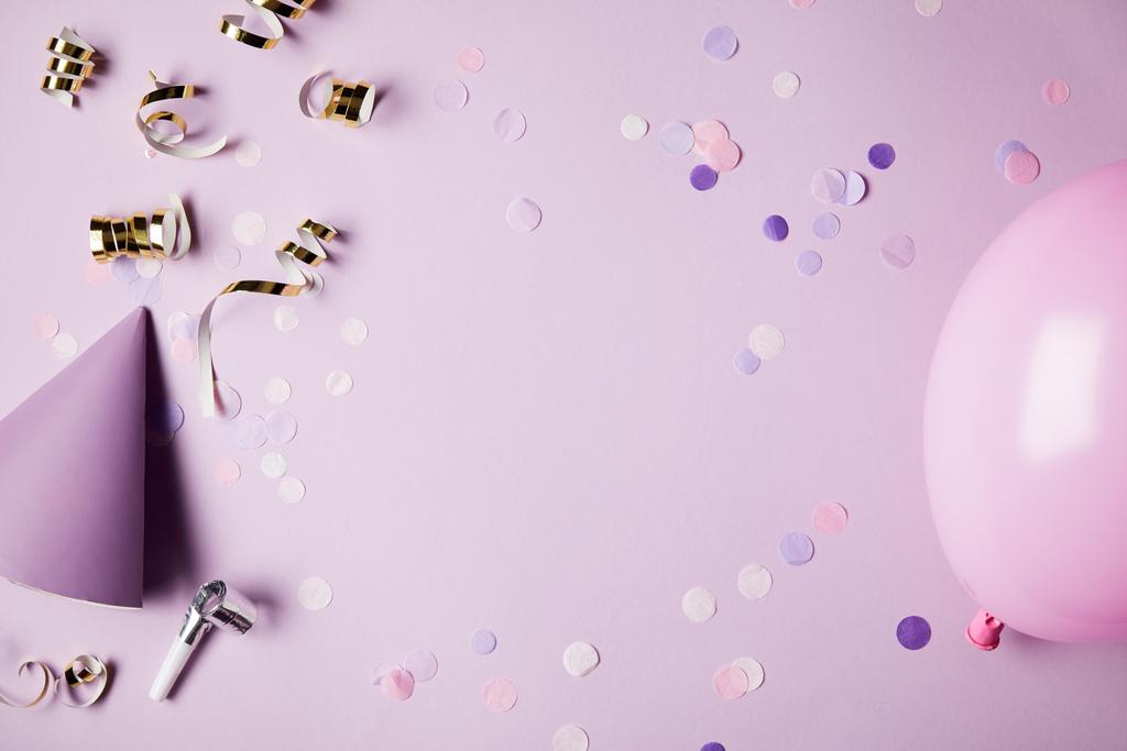 верхний вид конфетти части, воздушный шар и шляпа партии на фиолетовой поверхности
 - Фото, изображение
