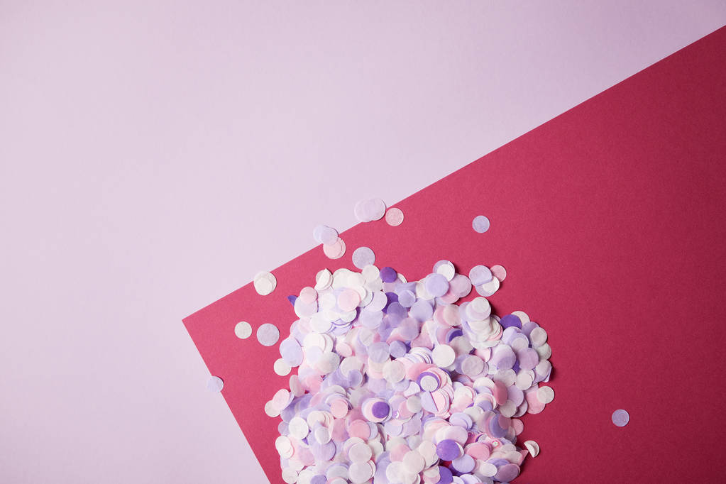 top view of confetti pieces on red and violet surface - Photo, Image