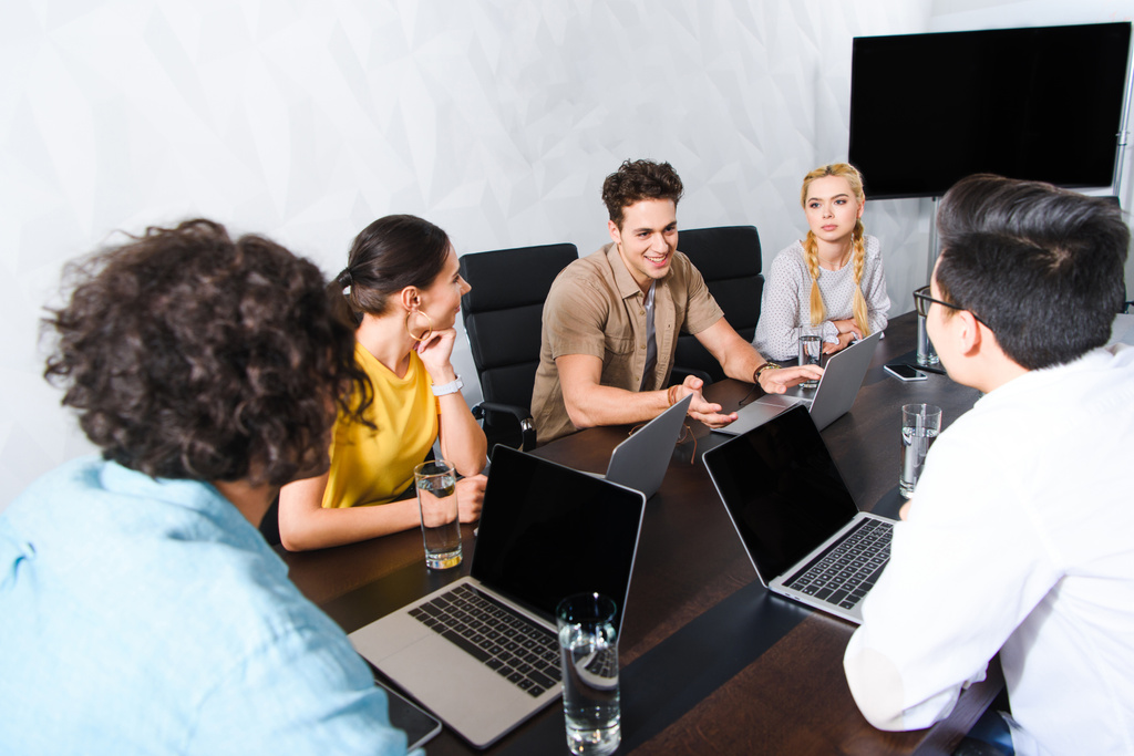 ομάδα από επιχειρηματίες πολυπολιτισμική έχοντας συζήτηση στο τραπέζι με φορητούς υπολογιστές στο σύγχρονο γραφείο  - Φωτογραφία, εικόνα
