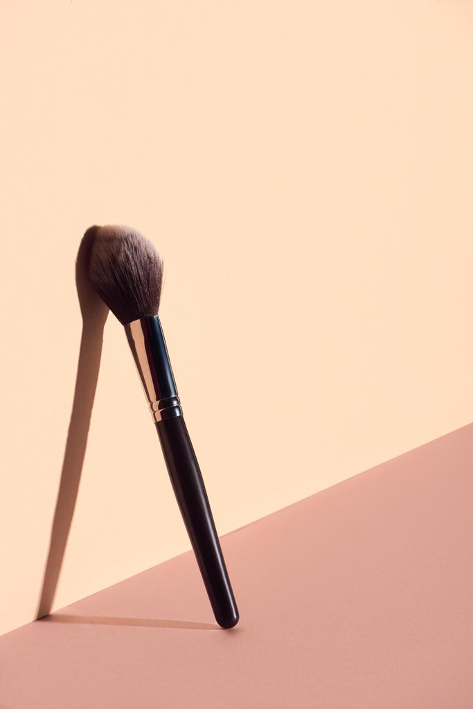 Cepillo de maquillaje de felpa sobre fondo beige
 - Foto, Imagen