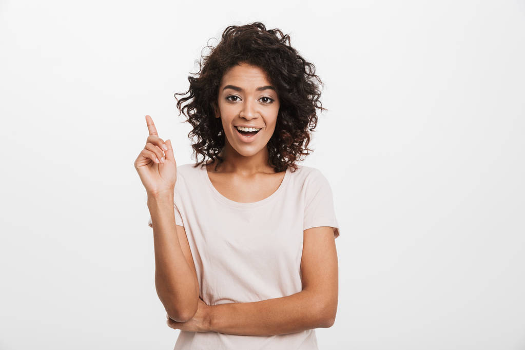 Portrét šťastné mladé afro americké ženy ukazující prst izolovaných na bílém pozadí - Fotografie, Obrázek