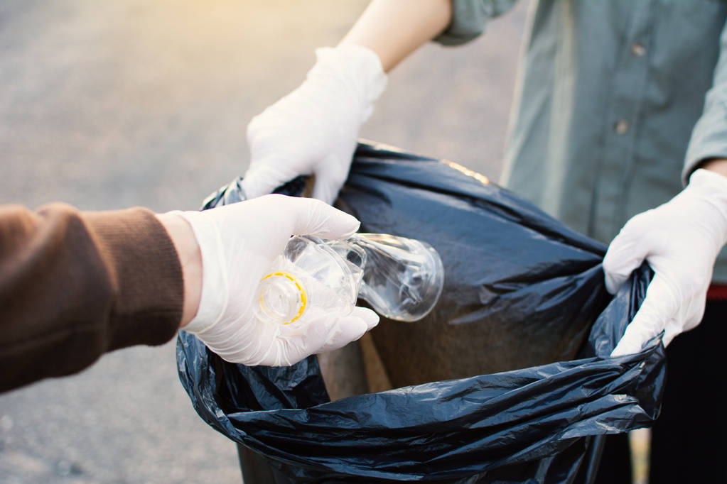 Lidská ruka zvedl prázdnou láhev plast na park, dobrovolnická koncept - Fotografie, Obrázek