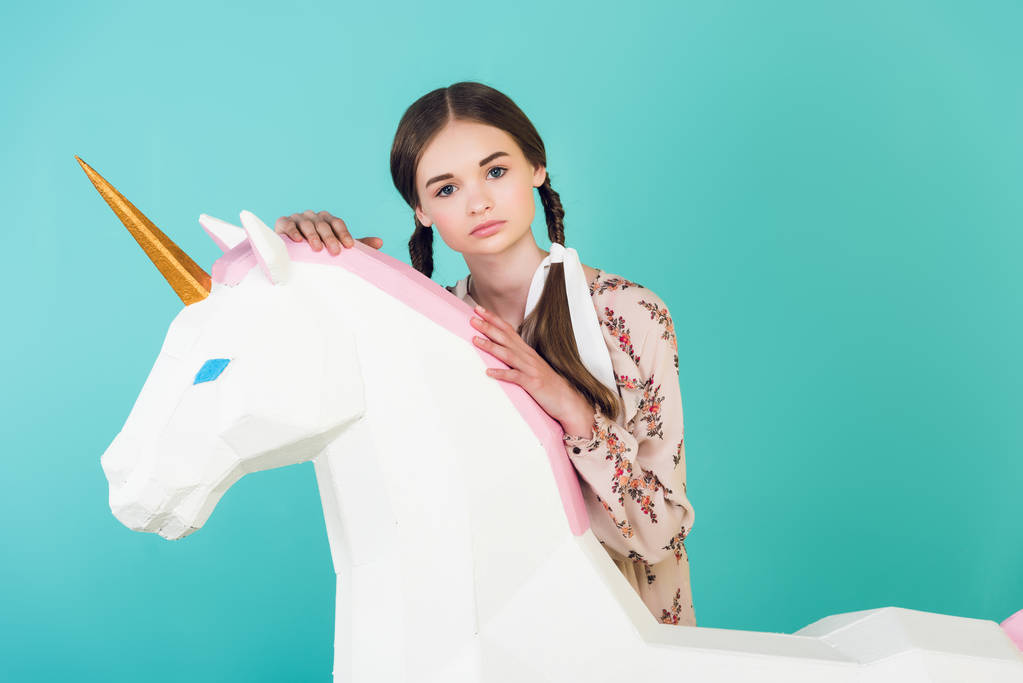 chica joven de moda posando con unicornio blanco grande, aislado en azul
 - Foto, Imagen