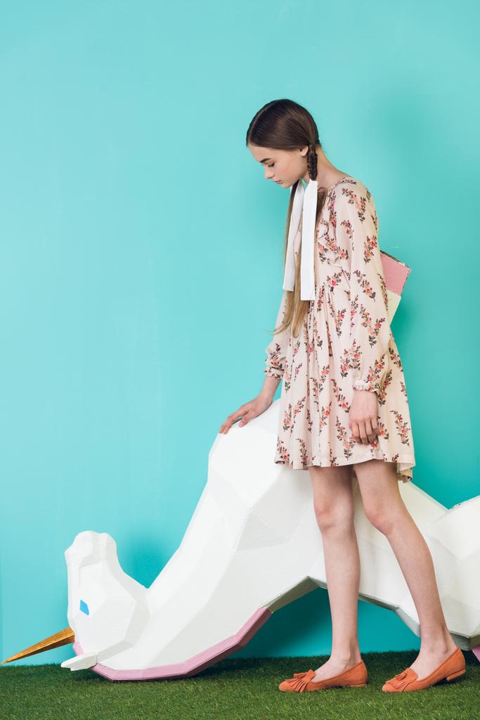 elegante ragazza adolescente in posa con grande unicorno a testa in giù, sul turchese
 - Foto, immagini