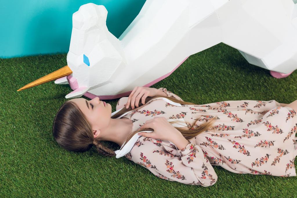 beautiful teen girl lying with big white unicorn   - Photo, Image
