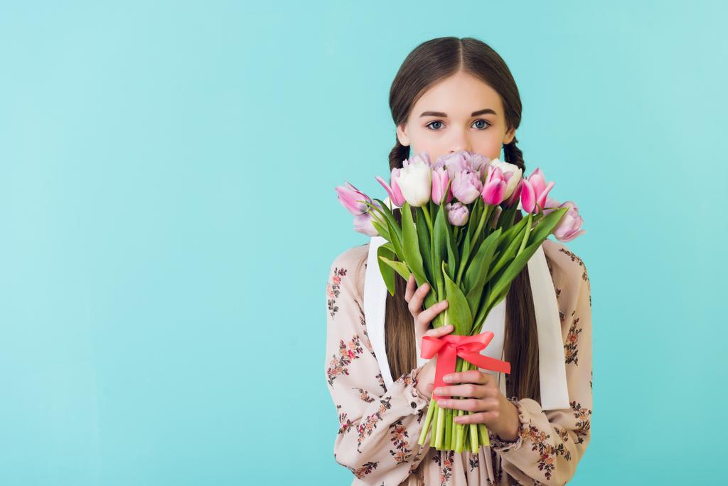 Teenie-Mädchen im trendigen Sommerkleid mit Tulpen, isoliert auf blau - Foto, Bild