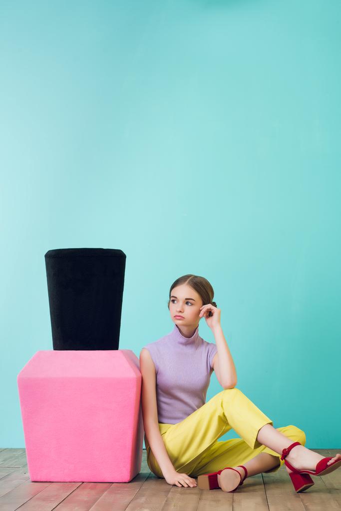 дівчина-підліток з великим лаком для нігтів, що сидить на підлозі
  - Фото, зображення
