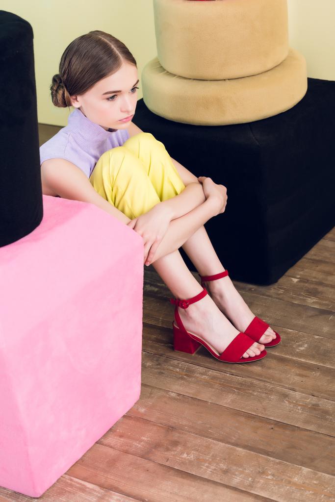 fashionable teen girl sitting near big nail polish and lipstick  - Photo, Image
