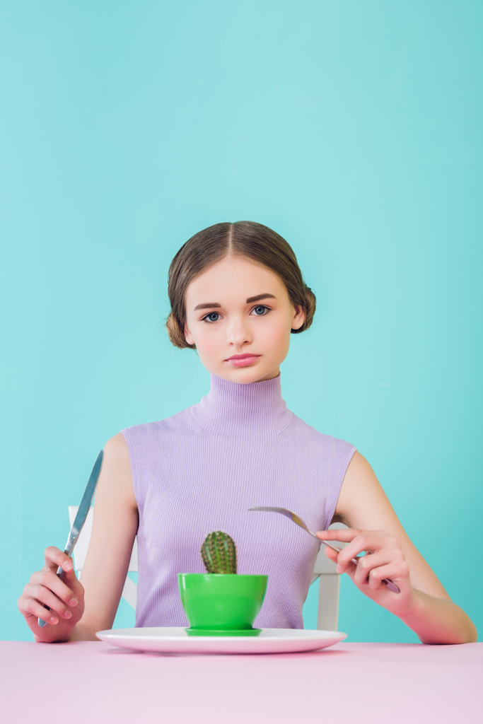 élégant adolescent femme mangeant cactus avec fourchette et couteau, concept de régime alimentaire
  - Photo, image