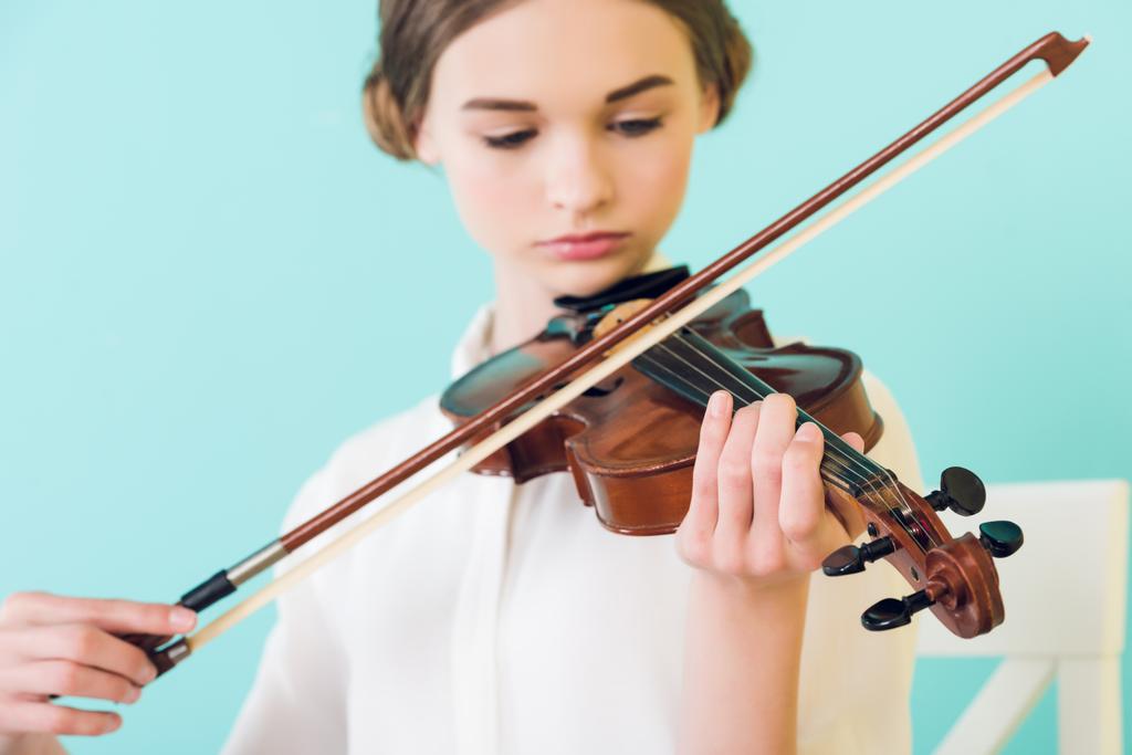 mooi meisje speelt viool, geïsoleerd op blauw - Foto, afbeelding