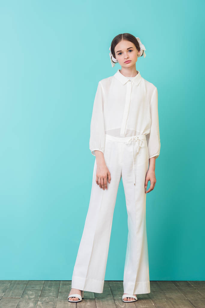 модна дівчина-підліток позує в білому вбранні на бірюзовому
 - Фото, зображення