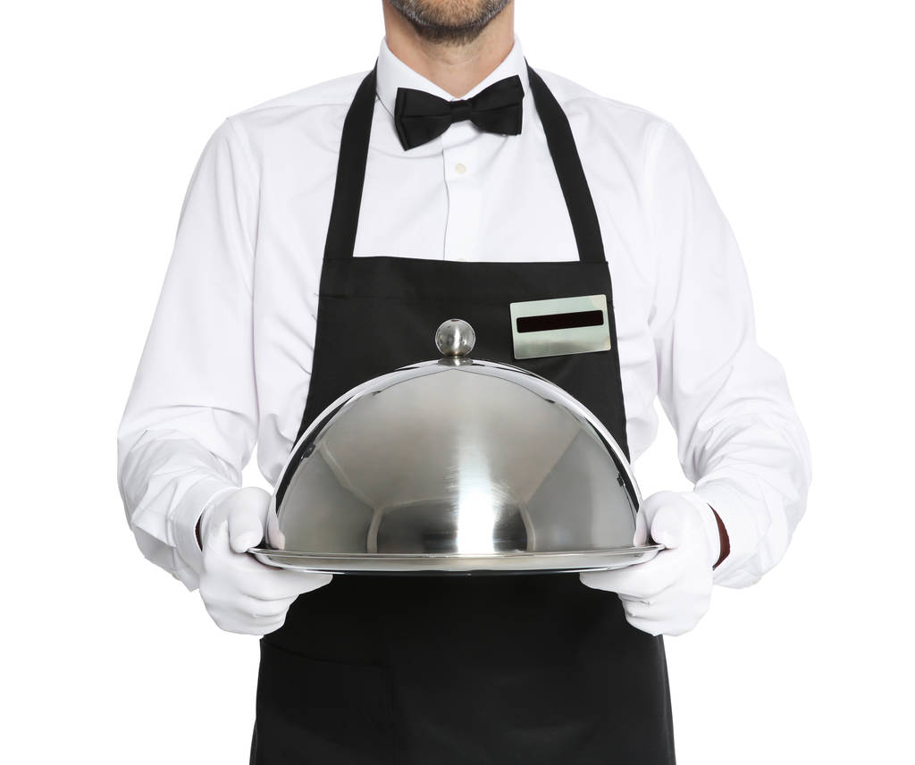 Νεαρά σερβιτόρος κρατώντας ΔΙΣΚΟΣ ΜΕΤΑΛΛΙΚΟΣ με καπάκι σε λευκό φόντο - Φωτογραφία, εικόνα