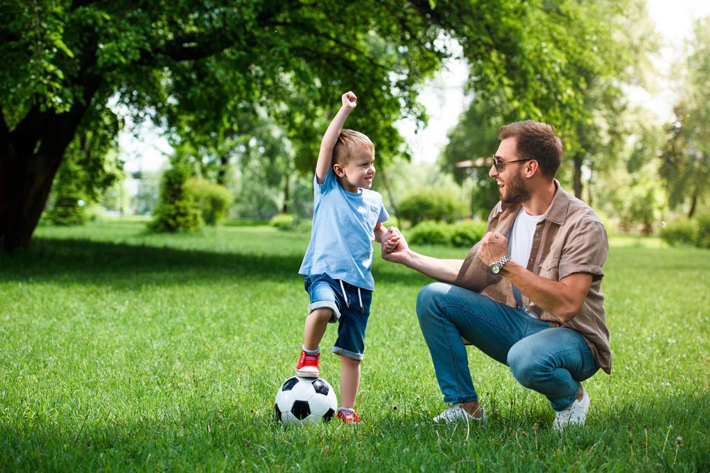 幸せな父と息子が公園でサッカーをプレイした後 [はい] 兆しを見せ - 写真・画像