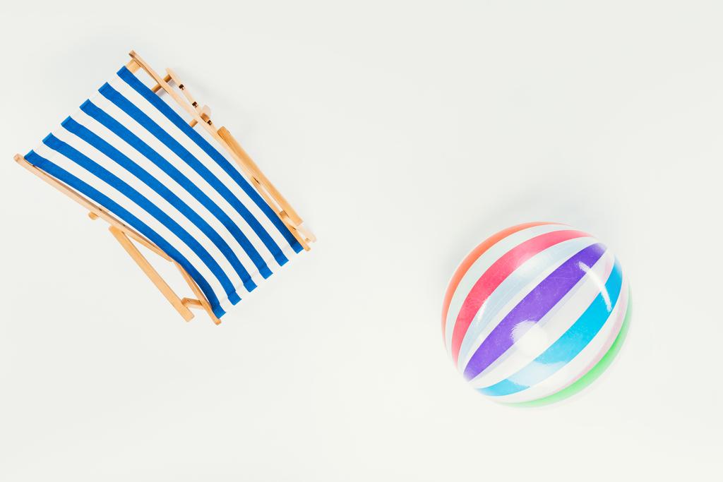 vista superior de la silla de playa rayada y bola de playa inflable aislada en blanco
 - Foto, imagen