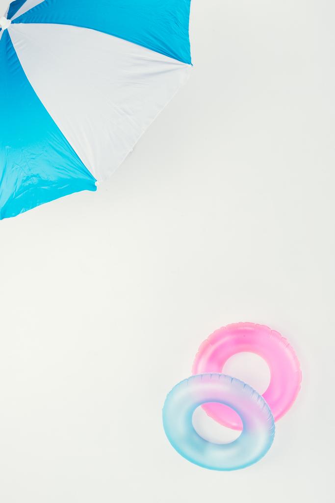 το Top view ομπρέλα και φουσκωτό δαχτυλίδια που απομονώνονται σε λευκό - Φωτογραφία, εικόνα