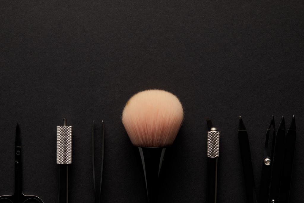 primer plano de las herramientas para el maquillaje permanente aislado en negro
 - Foto, Imagen