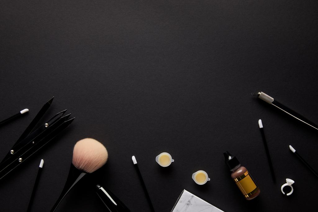 vue surélevée des outils pour un maquillage permanent isolé sur noir
 - Photo, image