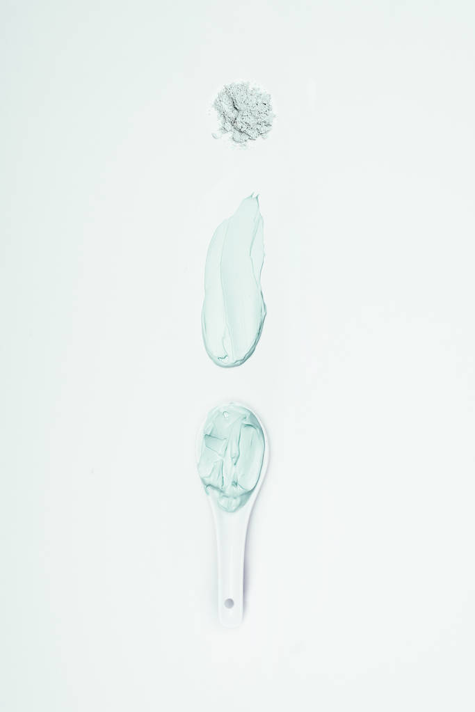 tendido plano con polvo de arcilla, mancha y cuchara con máscara de arcilla aislada en la superficie blanca
  - Foto, Imagen