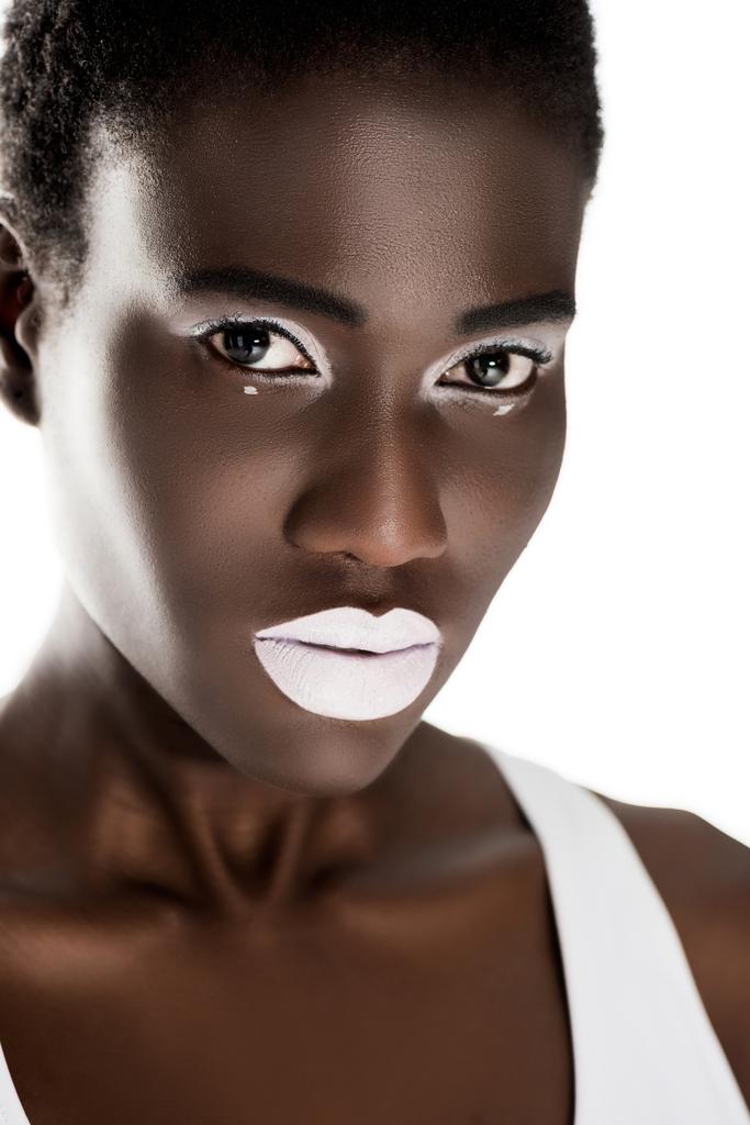 portrét krásné nabídky mladé afroamerické ženy s bílým make-upem při pohledu na fotoaparát izolované na bílém  - Fotografie, Obrázek