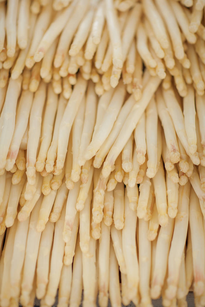 verse witte asperges ingericht op de wekelijkse markt, kan worden gebruikt als achtergrond - Foto, afbeelding