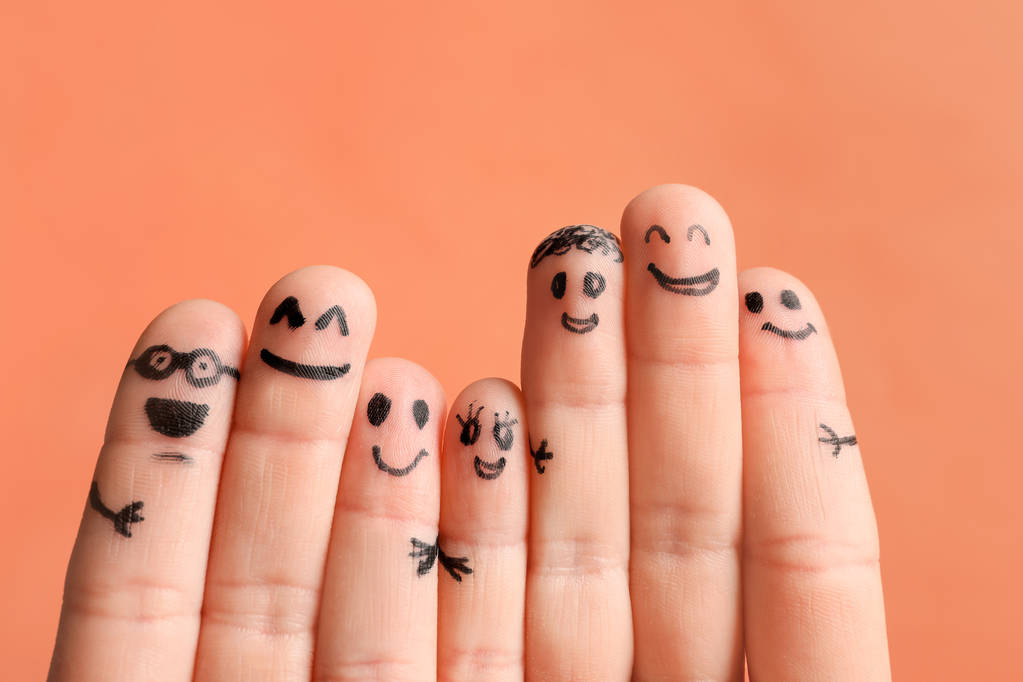 Τα δάχτυλα με τα σχέδια της χαρούμενα πρόσωπα κατά χρώμα φόντου. Έννοια της ενότητας - Φωτογραφία, εικόνα