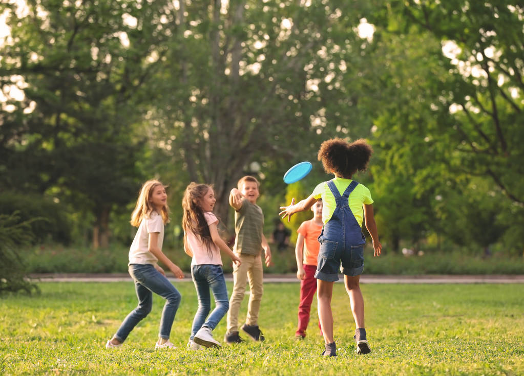 Bonito crianças brincando com frisbee ao ar livre no dia ensolarado
 - Foto, Imagem
