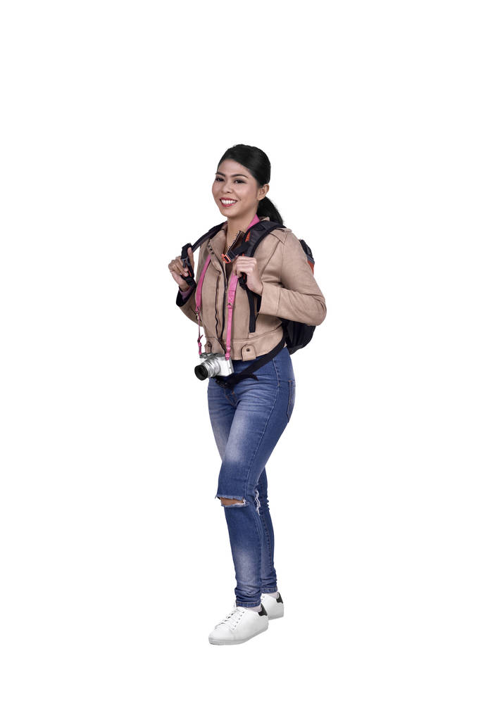 Portrait of asian traveler woman with camera and backpack standing isolated over white background - Photo, Image