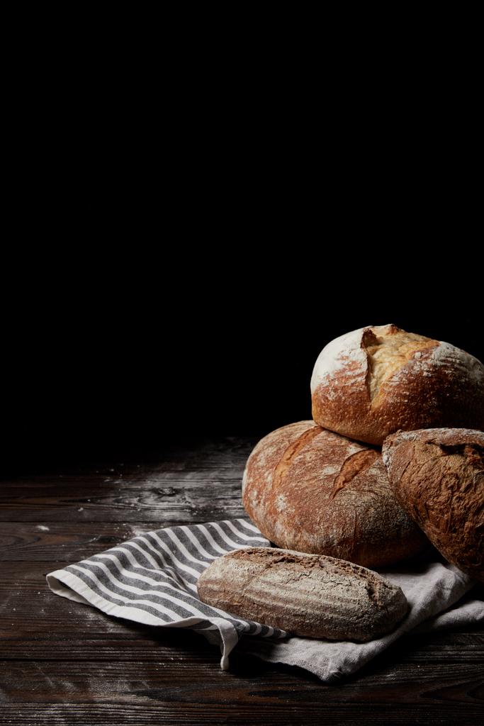 image rapprochée de différents types de pain et de sac sur une table en bois recouverte de farine
 - Photo, image