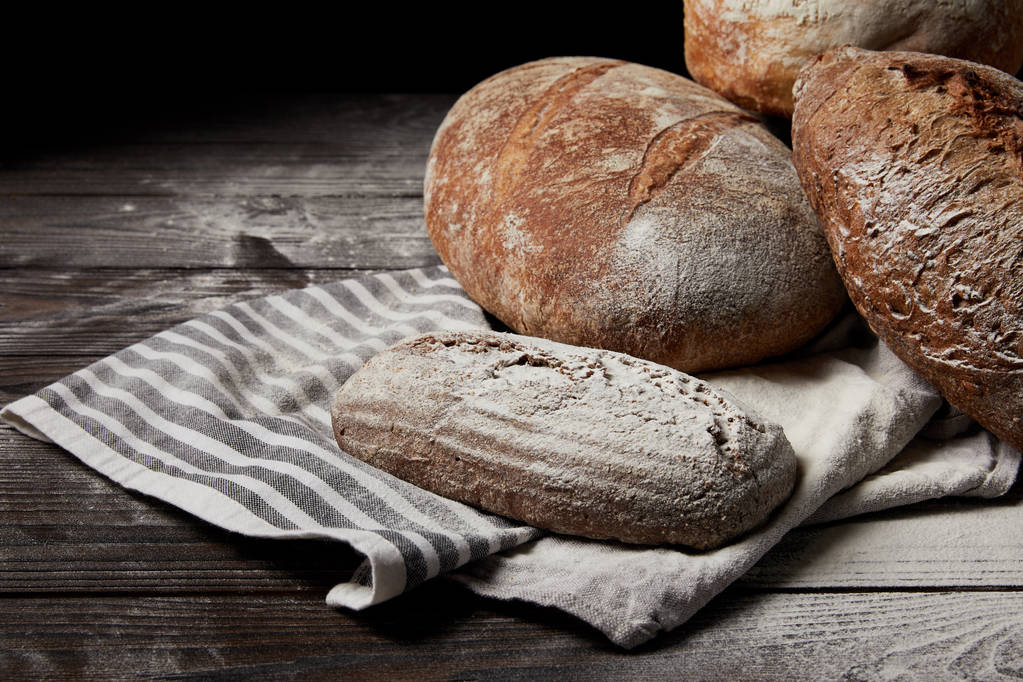 closeup image of various types of bread, flour and sackcloth on wooden table  - Photo, Image