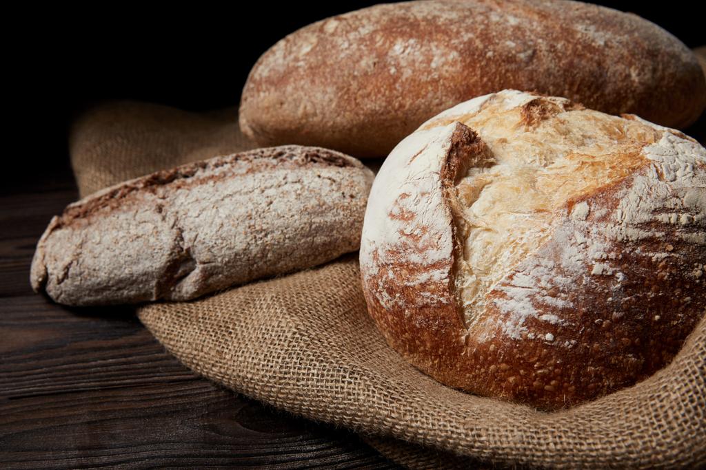 imagen de cerca de varios tipos de pan y saco en la mesa de madera
  - Foto, Imagen