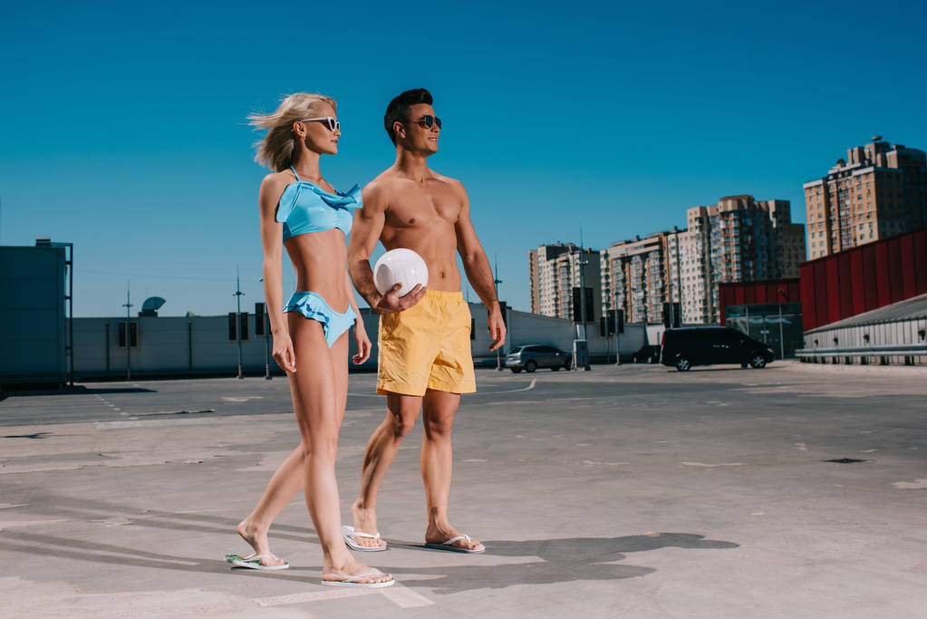 fiatal pár, strand röplabda labda a parkolás ruha - Fotó, kép