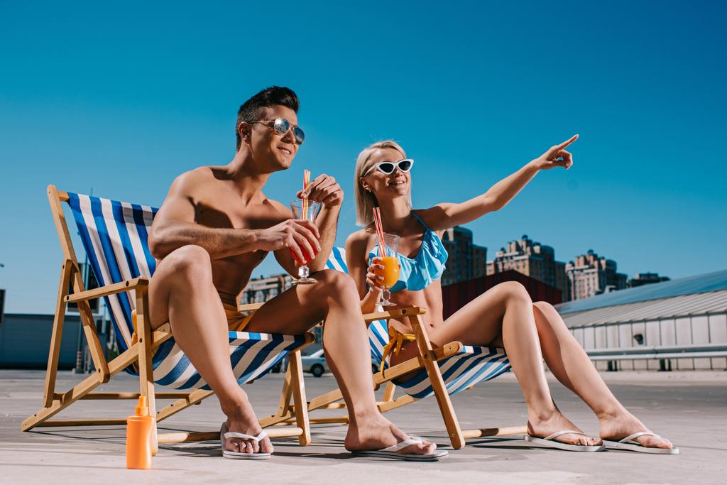 nuori pari cocktaileja istuu aurinkotuoleja pysäköinti
 - Valokuva, kuva