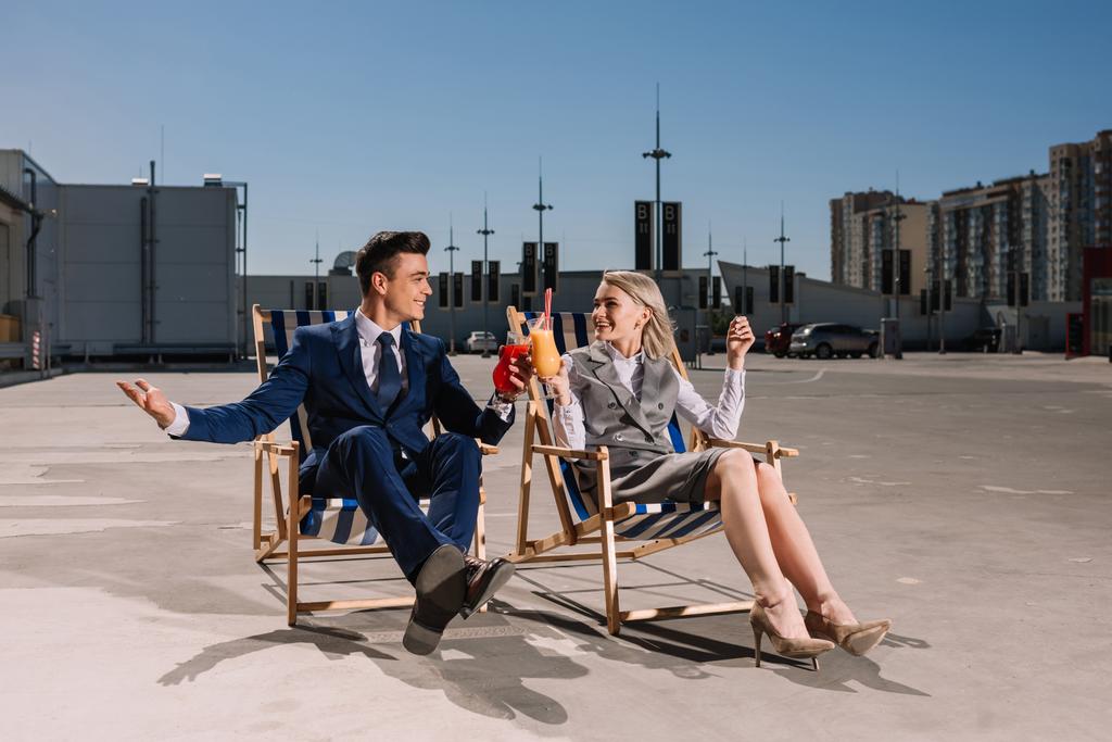 fiatal üzleti emberek pihennek a napozóágyak csengő poharak, koktélok, a parkolás - Fotó, kép