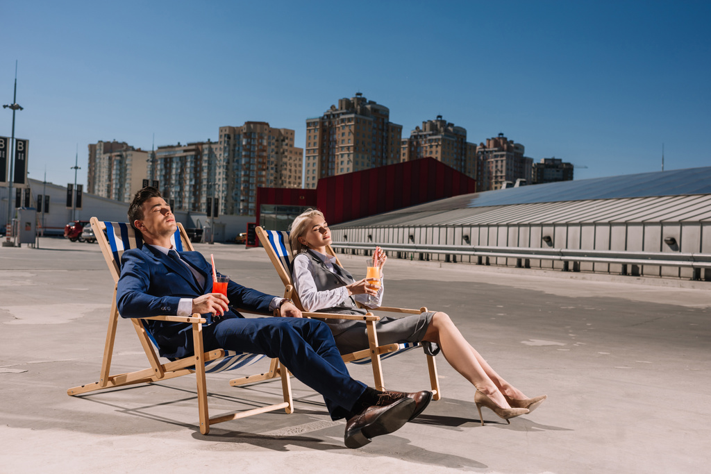 jeunes gens d'affaires se détendre sur des chaises longues avec des cocktails sur le parking
 - Photo, image