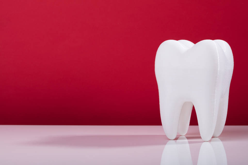Mondelinge tandheelkundige gezonde witte tand op grijze achtergrond - Foto, afbeelding
