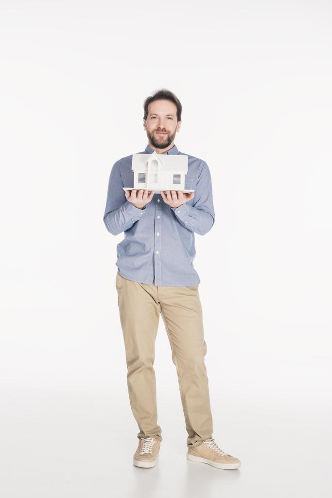 bärtiger Mann hält Hausmodell in Händen isoliert auf weißem Grund - Foto, Bild