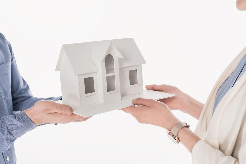 обрезанный снимок пары, держащей модель дома изолированы на белом
 - Фото, изображение