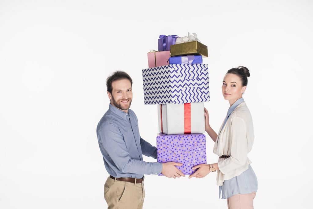 вид збоку пари, що тримає купу загорнутих подарунків разом ізольовано на білому
 - Фото, зображення