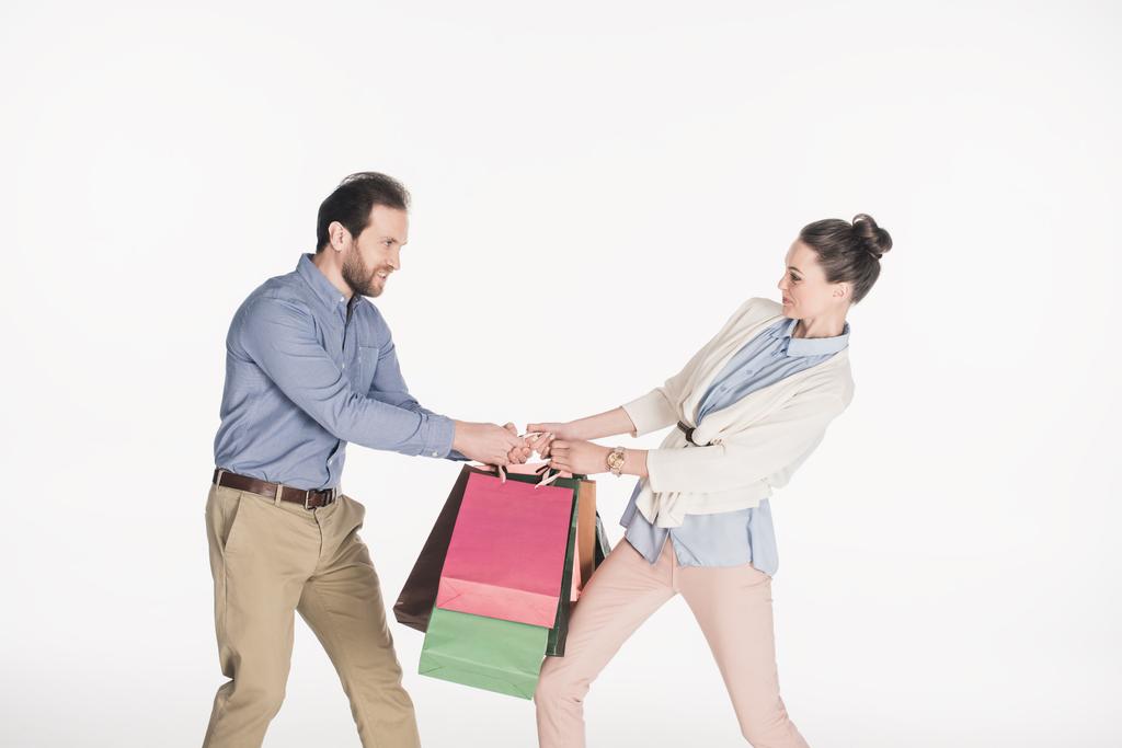 vista laterale di coppia tirando oltre shopping bags isolato su bianco
 - Foto, immagini