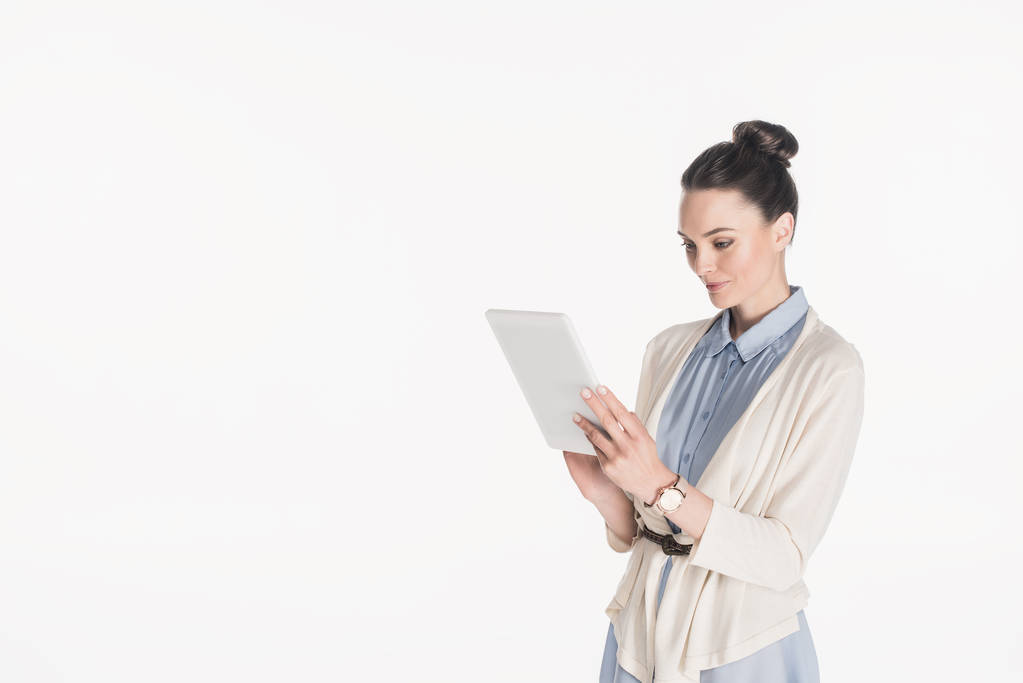 vista lateral de la mujer en ropa casual utilizando tableta digital aislada en blanco
 - Foto, imagen