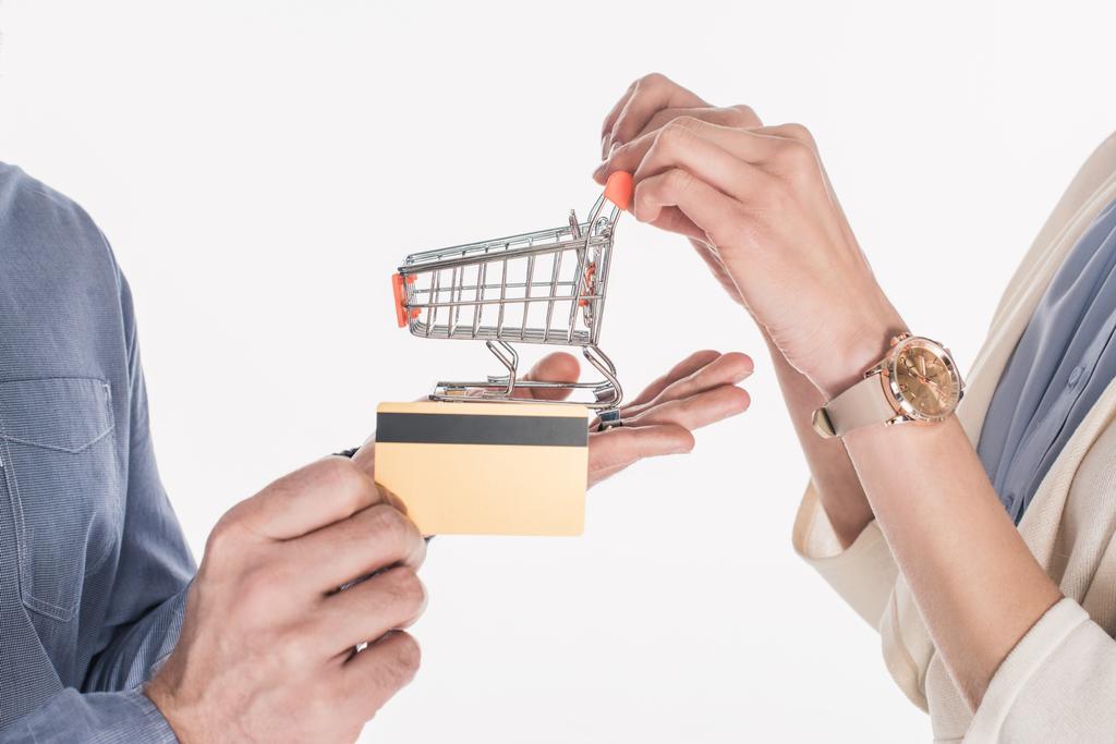 küçük alışveriş sepeti ve kredi kartı üzerinde beyaz izole elinde tutan bir çift atış kırpılmış - Fotoğraf, Görsel