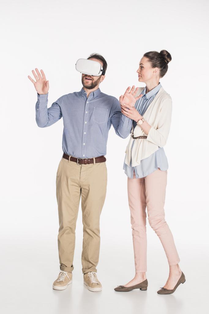 muž v soupravu pro virtuální realitu s manželkou nedaleko od izolovaných na bílém - Fotografie, Obrázek