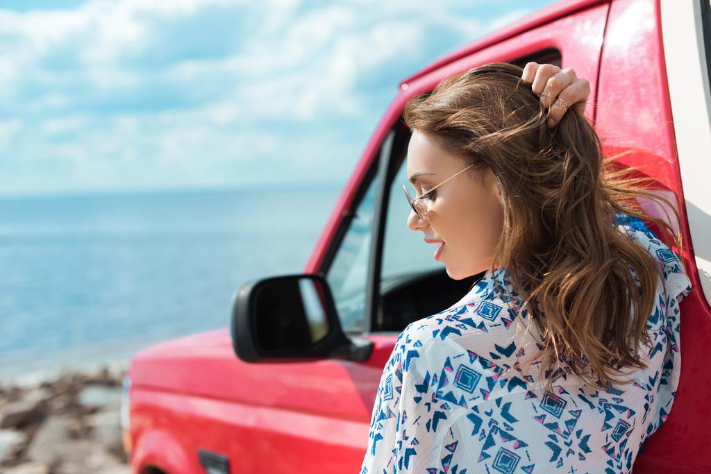 schöne stilvolle Frau am Auto während einer Autofahrt in der Nähe des Meeres - Foto, Bild