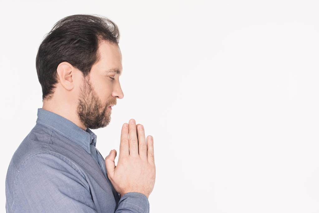 widok boczny Brodaty mężczyzna w koszuli, modląc się na białym tle - Zdjęcie, obraz