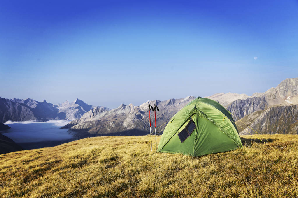 Палатка на вершине горы. Солнечная панель висит на палатке.
. - Фото, изображение