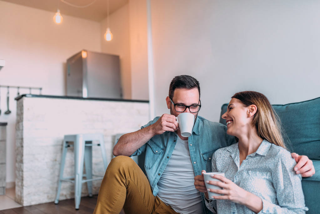 νέοι ευτυχισμένο ζευγάρι χαλαρώνοντας στο σπίτι πίνοντας τσάι  - Φωτογραφία, εικόνα