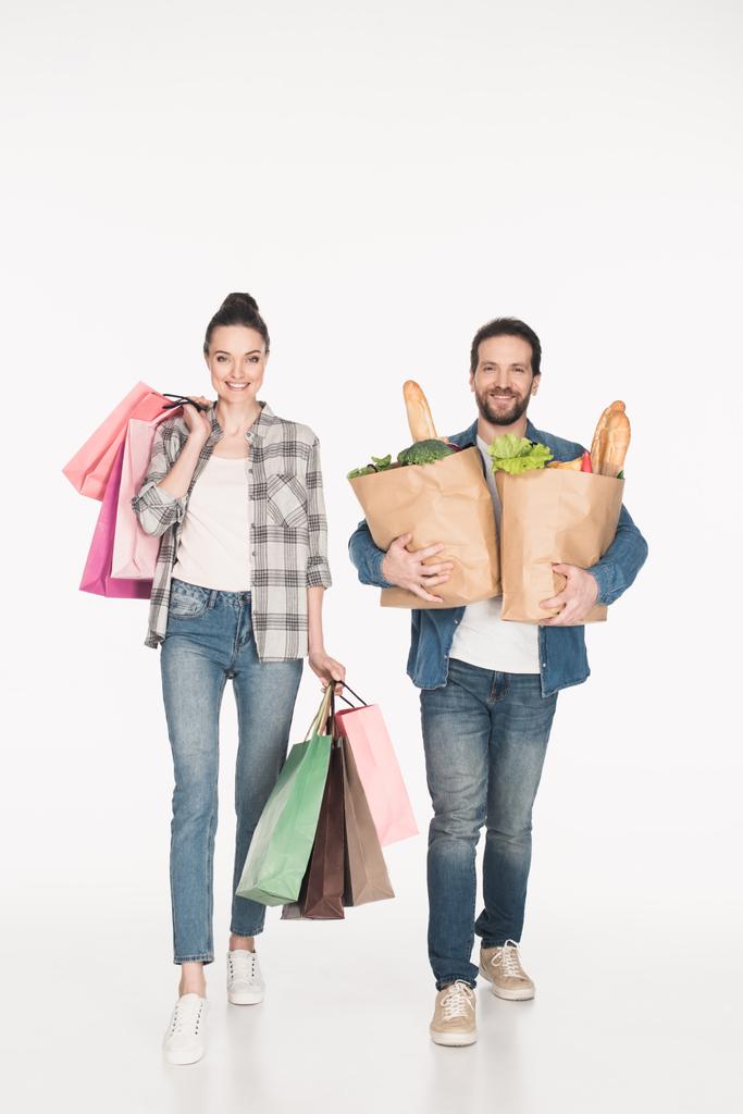 χαρούμενη γυναίκα και ο άντρας που μεταφέρουν τσάντες για ψώνια και χαρτί πακέτα γεμάτα τρόφιμα απομονωμένα σε λευκό - Φωτογραφία, εικόνα