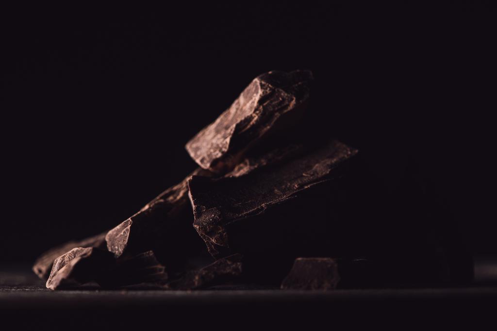 primo piano vista di pezzi di cioccolato fondente su sfondo nero
  - Foto, immagini