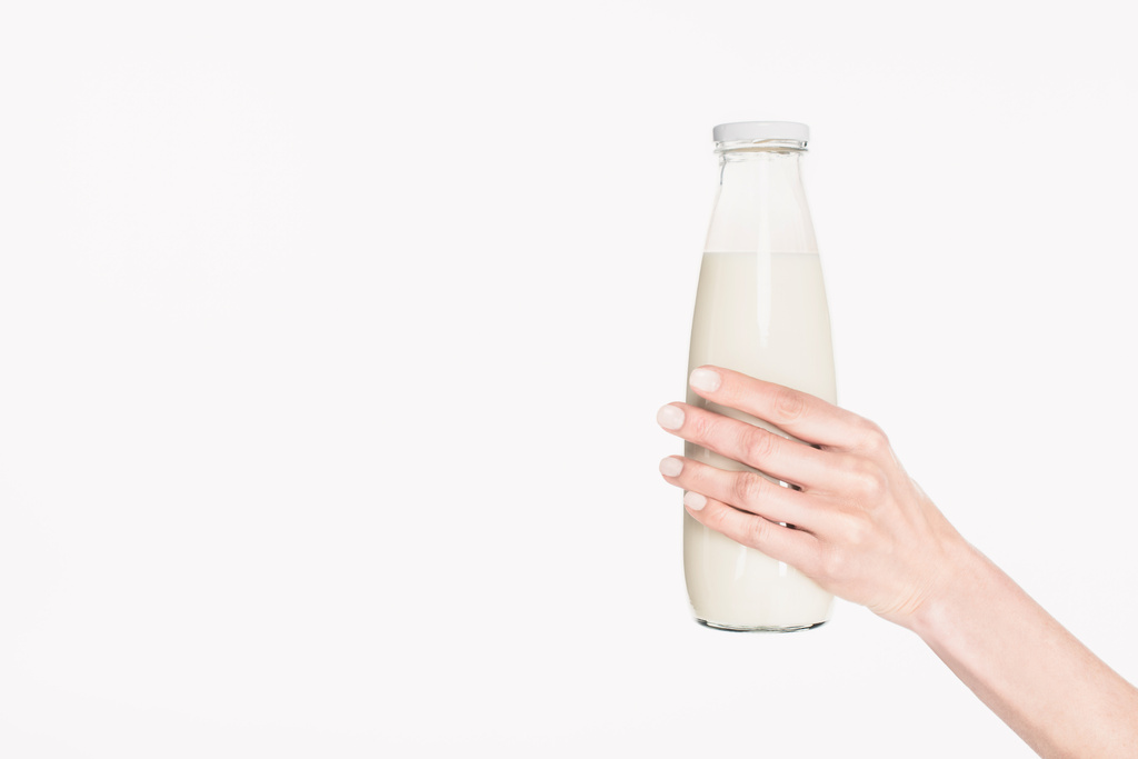 plan recadré de la femme tenant bouteille en verre de lait isolé sur blanc
 - Photo, image