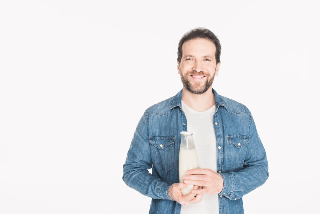 πορτρέτο της χαμογελαστός άνθρωπος με γυάλινο μπουκάλι γάλα στα χέρια βλέπουν τα φωτογραφικών μηχανών που απομονώνονται σε λευκό - Φωτογραφία, εικόνα